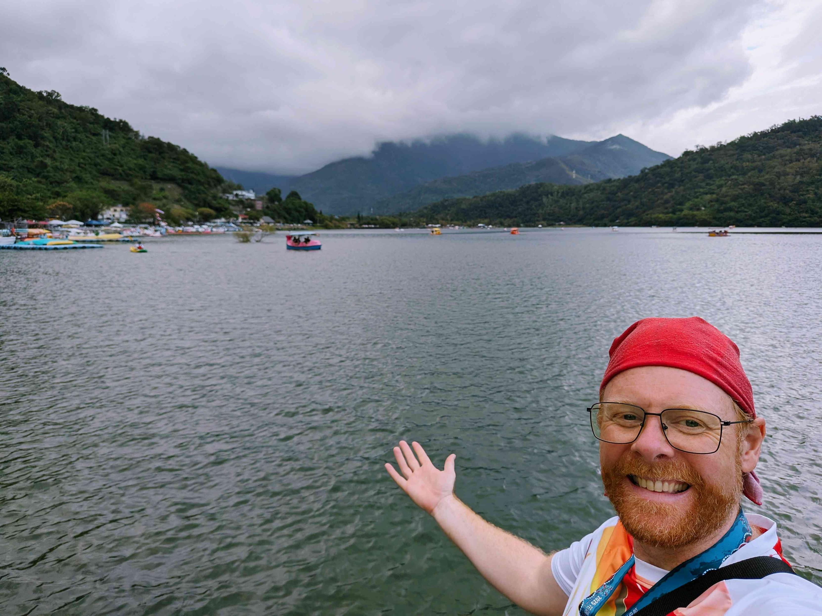 Me waving at the beautiful lake with the mountains in the background 